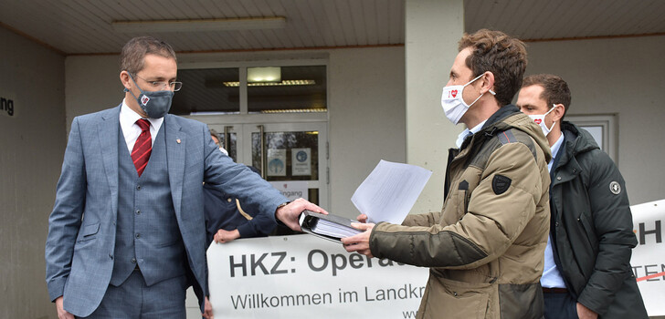Die beiden Initiatoren Tim (im Vordergrund) und Benjamin Schneider übergeben Landrat Dr. Michael Koch (links) die Petition.