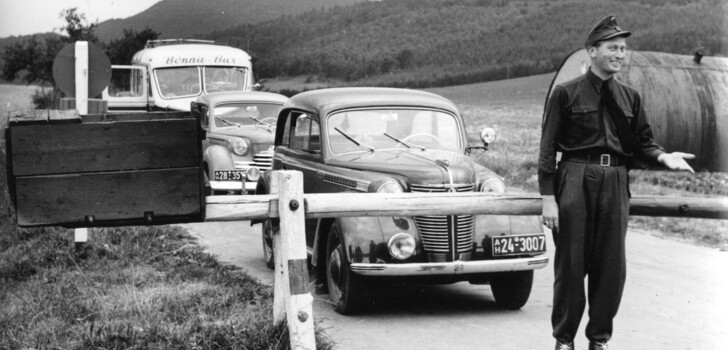 Ein Beamter des Bundesgrenzschutzes steht 1952 vor dem geschlossenen Schlagbaum an der deutsch-deutschen Grenze bei Heldra.