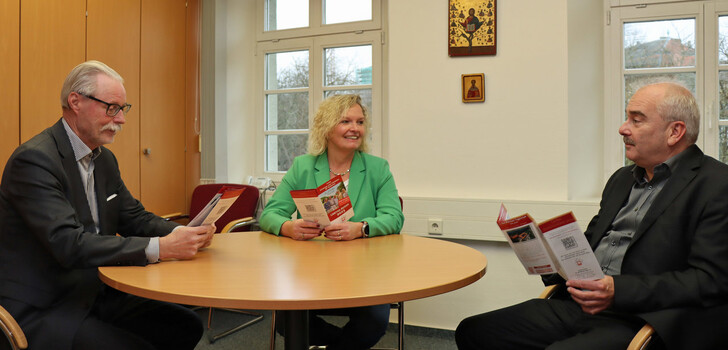 Simone Möller und Franz Meyer als zuständiges Team stellen Diözesan-Caritasdirektor Juch (re.) das neue Seniorenreiseprogramm vor.