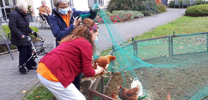 Die Hühner locken immer wieder Bewohnerinnen und Bewohner in den Garten; an der Ferch die für den Sozialen Dienst zuständigen Josefsheim-Mitarbeiterinnen Klingelhöfer und Fuchs.