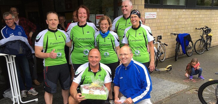 v.l.: Kapitän Frank Sandrock nimmt für sein Team "Funspinner" von Radsport-Präsident Carsten Lenz für die zweitgrößte Gruppe ein Wurstpaket zur Stärkung entgegen