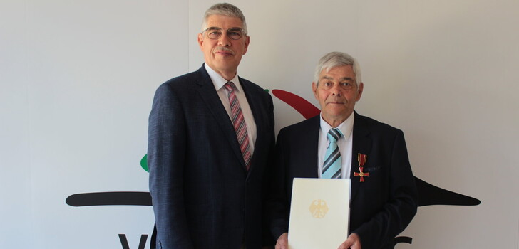 Gerührt zeigt sich Gerhard Wettlaufer, nachdem ihm Landrat Manfred Görig das Bundesverdienstkreuz am Bande ans Revers geheftet hat.