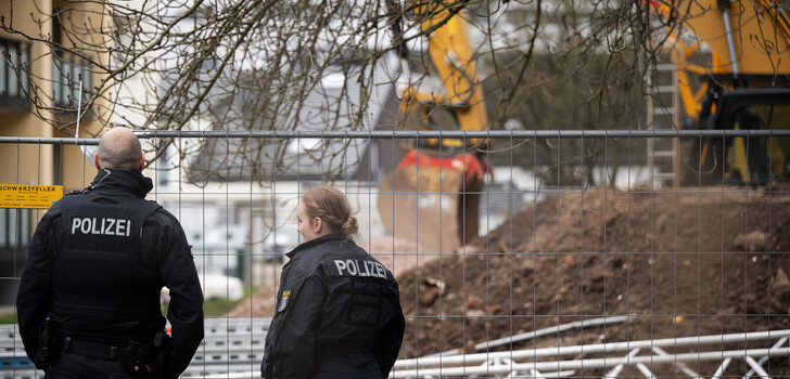 Polizeibeamte stehen am Fundort der Fliegerbombe an einer Baustelle