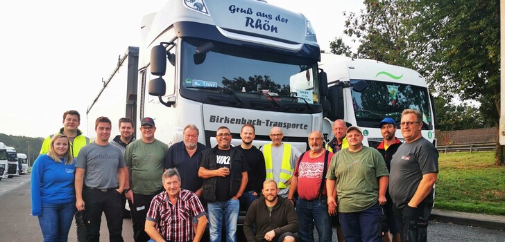 Auf diesem Bild sind Daniel Krimmel, Florian Link und Carsten Detig vom Team Rhön mit den LKW-Fahrern zu sehen, die am Samstag den Konvoi gefahren sind