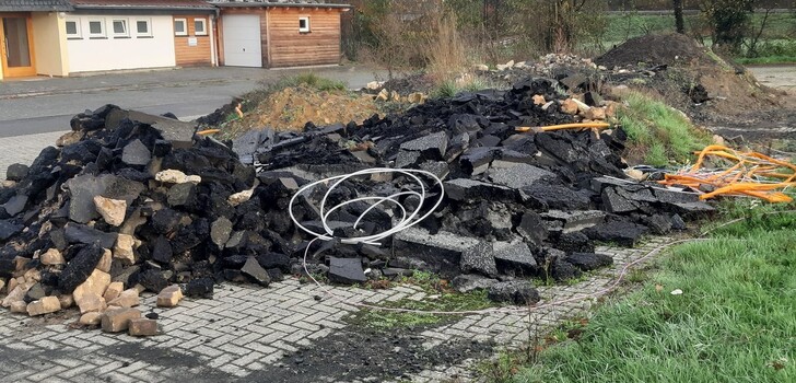 Der anfallende Erdaushub sowie der abgetragene Asphalt liegt noch immer auf dem Vorplatz des Dorfgemeinschaftshauses in Lehrbach.