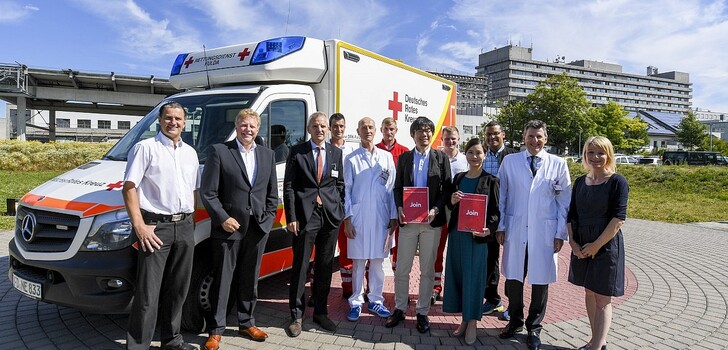 Obligatorisches Gruppenbild (v.li.): DRK-Wachenleiter Marko Hellmich,
DRK-Geschäftsführer Christoph Schwab, vom Klinikum Fulda: Priv.-Doz. Dr. Thomas Menzel (Vorstand) und Prof. Dr. C.-A. Greim, die Delegation aus Japan, Prof. Dr. Martin H. Hessmann (Klinikum Fulda) sowie Nicole Weider - im Hintergrund: das diensthabend Rettungsdienstpersonal des DRK Fulda.