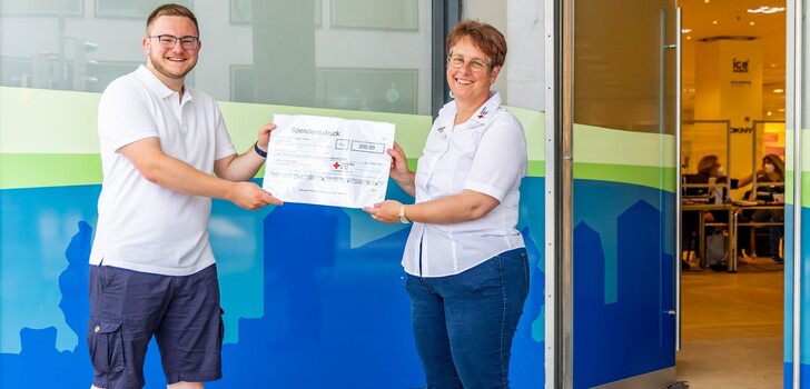 Tom Seifert, Initiator der Wette der Eduard-Stieler-Schule, erhält den Scheck aus den Händen der Blutspendebeauftragten Katja Krah