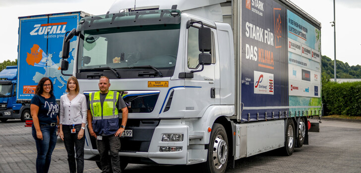 Kathrin Fehler, Charlotte Jahn und Sascha Schlote vor dem Prototyp des E-Lkw der Marke MAN